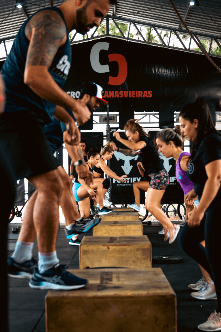 Atletas do CrossFit Canasvieiras fazendo saltos em caixa durante o treino.