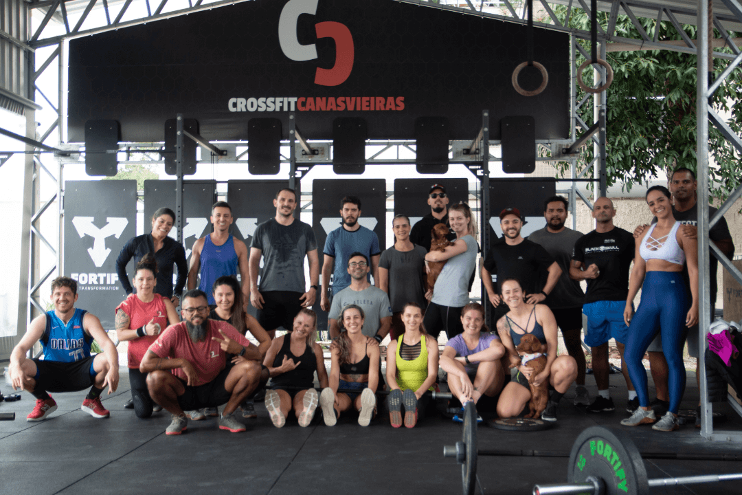 Turma do CrossFit Canasvieiras reunida no box em Canasvieiras (Florianópolis) após o treino, com coaches e alunos posando sob o banner do box.